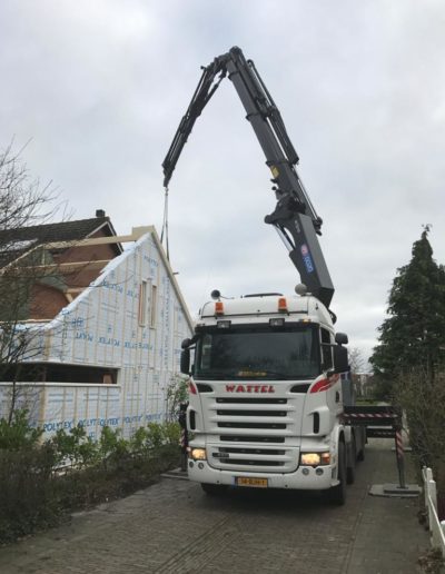 Autolaadkraan met uitgeschoven arm bij aanbouw