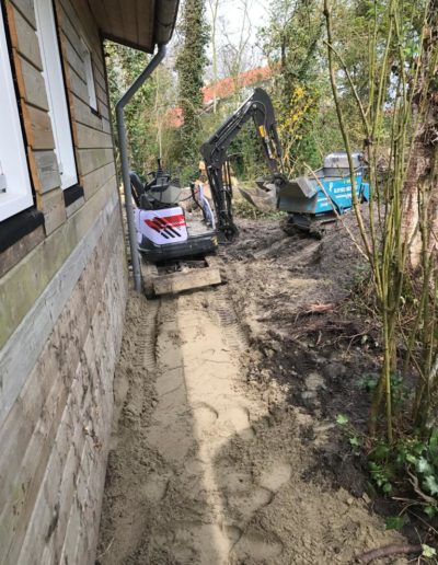 Minigraver in tuin met puinbak